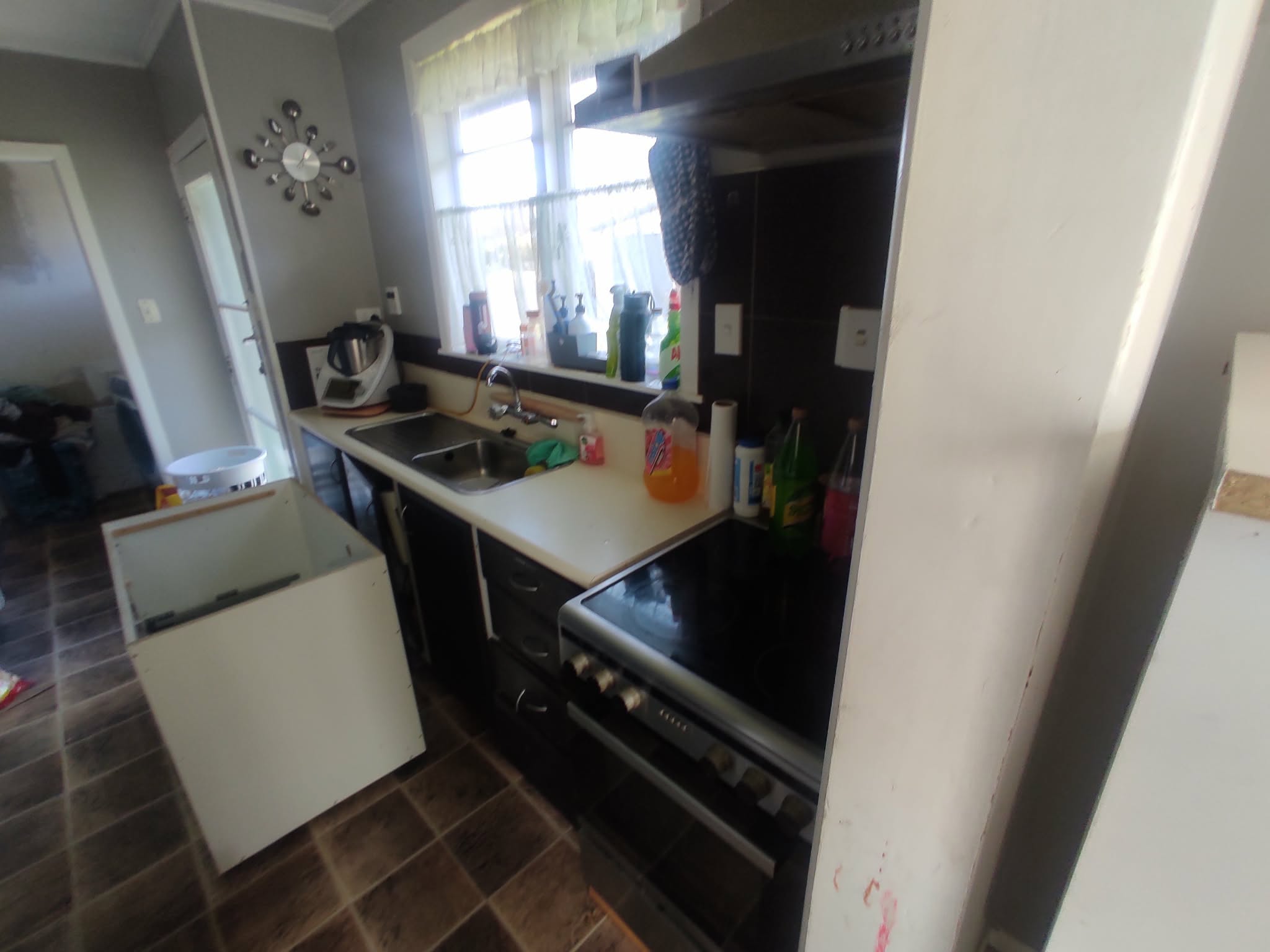 The kitchen before renovation - broken cabinet door and mismatched units