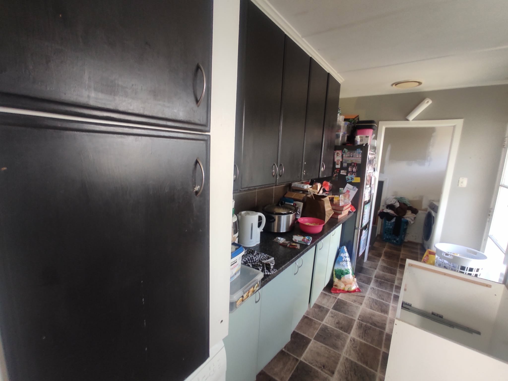 The kitchen before renovation - dark worn cabinets and cluttered counters